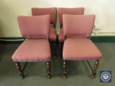Four oak dining chairs in a red patterned fabric