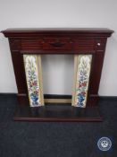 A mahogany effect fire surround with tiles