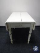 An antique painted pine drop leaf kitchen table