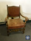 A 20th century carved oak scroll arm armchair