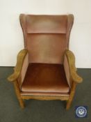 A continental oak wing back chair in pink fabric