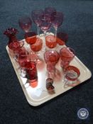A tray of antique and later cranberry glass ware, jugs, vases, wine glasses etc.