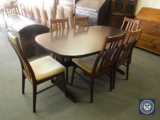 A mahogany extending dining table with leaves and six rail back chairs