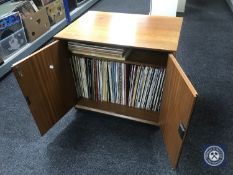 A teak double door record cabinet containing LP's