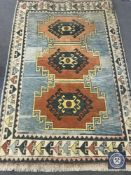 A fringed woollen rug of geometric design