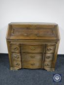 A continental oak serpentine fronted three drawer bureau