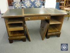 A continental oak and walnut twin pedestal desk fitted a drawer and cupboards with three tooled
