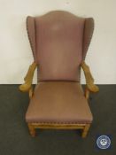A continental oak wingback chair in pink fabric