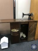 A Singer sewing machine in oak cabinet