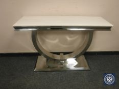 A contemporary polished steel console table with white polished stone top,