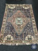 An Iranian Khamseh rug on mauve ground