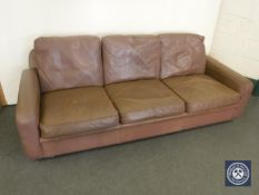 A mid 20th century brown leather three-seater settee