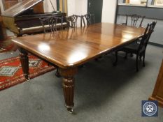 A Victorian mahogany extending dining room table, on reeded legs, with two leaves,