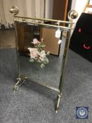 An early 20th century brass mirrored fire screen