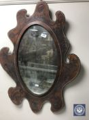 A 20th century mirror in tooled leather frame