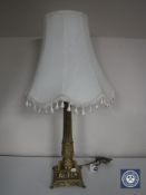 A heavy brass table lamp with shade
