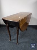 A mahogany drop leaf table on club feet