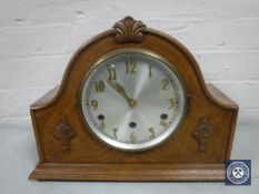 An early 20th century oak mantel clock with silvered dial