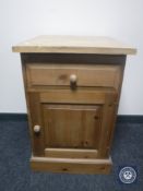 A stripped pine cupboard fitted a drawer