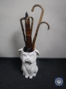 A stick pot containing assorted walking sticks, umbrellas,