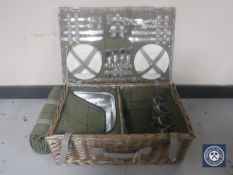 A wicker picnic basket with travel rug