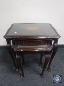 A nest of tables together with a wall shelf