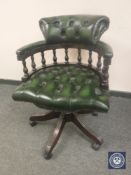 A green buttoned-leather Chesterfield style swivel chair,