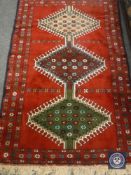 A Caucasian design rug on red ground,