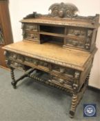 A Victorian heavily carved oak Green Man writing desk, width 119 cm.
