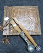 An embossed leather photograph album together with a set of six spoons on rack