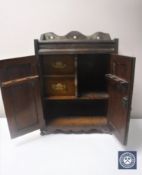 A Victorian oak double door smoker's cabinet with carved panel doors