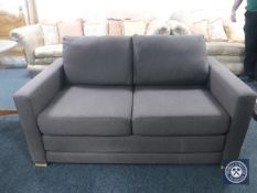 A contemporary two seater bed settee in brown fabric