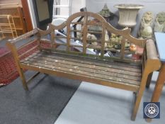 A wooden scroll arm garden bench