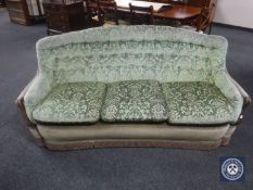 A mid 20th century shaped three seater settee in green brocade