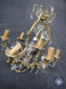 An antique gilt metal five-way light fitting with glass drops