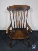 An antique elm kitchen armchair