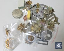 A box of militaria to include cap badges,