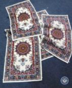 A set of four Persian design rugs on cream ground