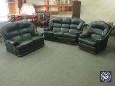 A green leather three-piece suite comprising three seater settee,