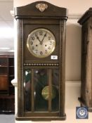 An oak cased wall clock with silvered dial,