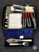 A tray of boxed and loose sets of flatware