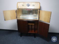 A mid 20th century cocktail cabinet with record cabinet beneath