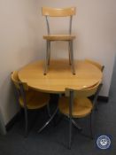 A kitchen table on metal base with four chairs