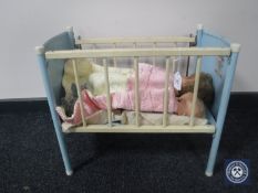 A mid 20th century doll's metal cot and two dolls