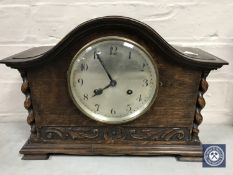 An oak cased Junghans mantel clock with barley twist supports and enamelled dial,