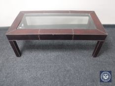 A contemporary leather glass topped coffee table