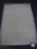 A hand tufted border design beige rug, 120 cm x 180 cm, rrp £297.