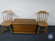 A pine blanket box and pair of pine dining chairs