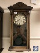 An oak cased wall clock with silvered dial,