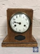 An oak cased continental bracket clock with enamelled dial,